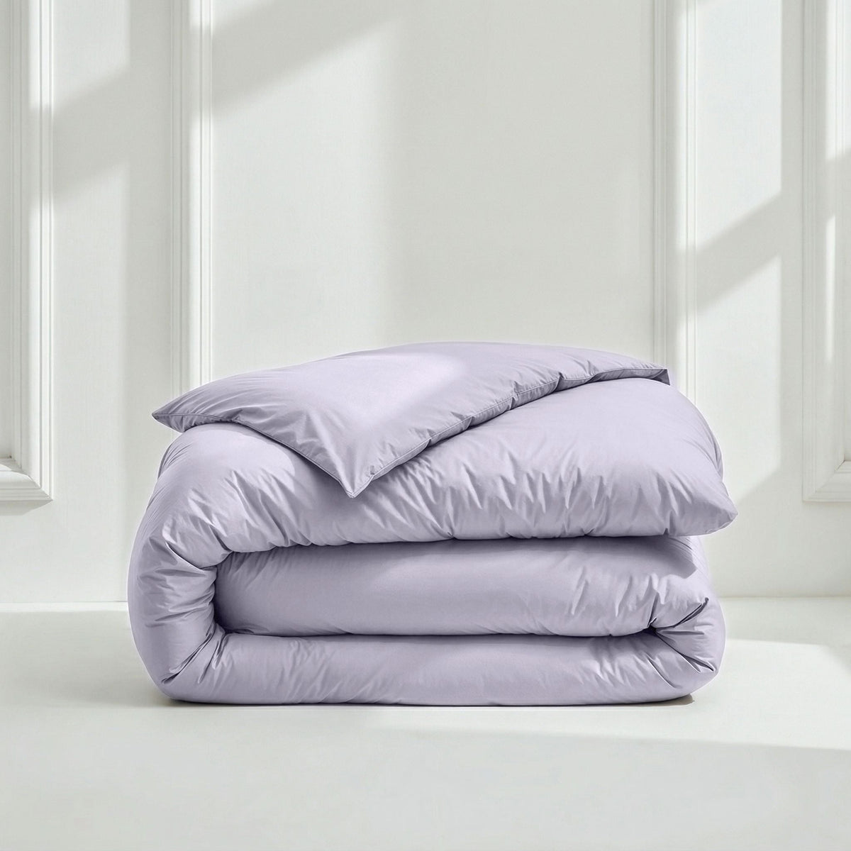Folded lavender sateen duvet cover against white background with molding
