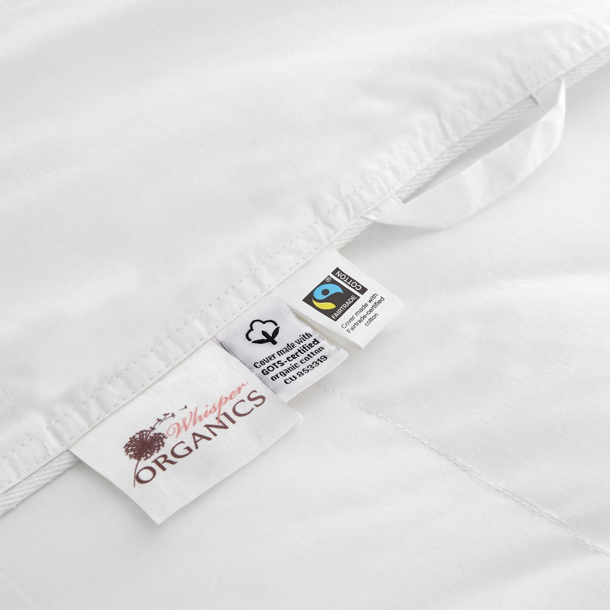 Product tags showing Whisper Organics logo, GOTS certified organic cotton mark, and Fairtrade certification