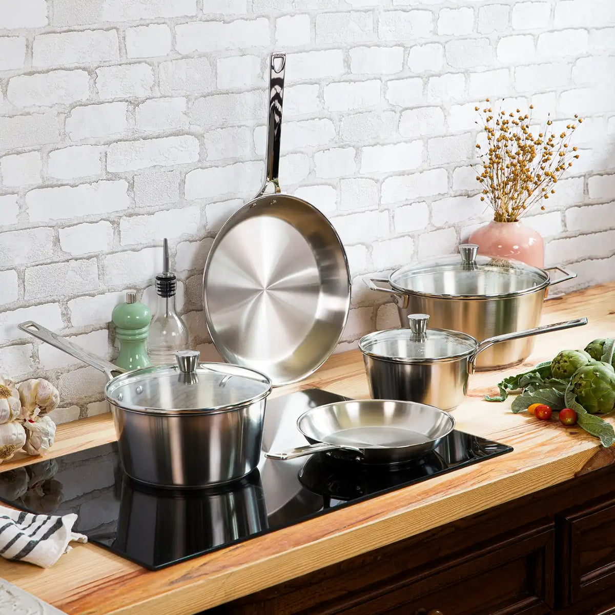 CRISTEL 1826 stainless steel pots on induction cooktop with glass lids and fresh vegetables