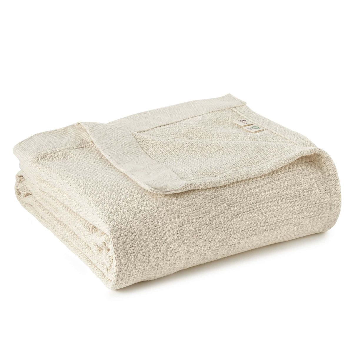 Folded off-white organic woven blanket with waffle texture and branded tag on white background