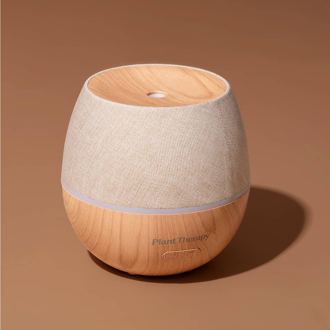 Studio shot of beige linen and wood grain diffuser against solid brown backdrop