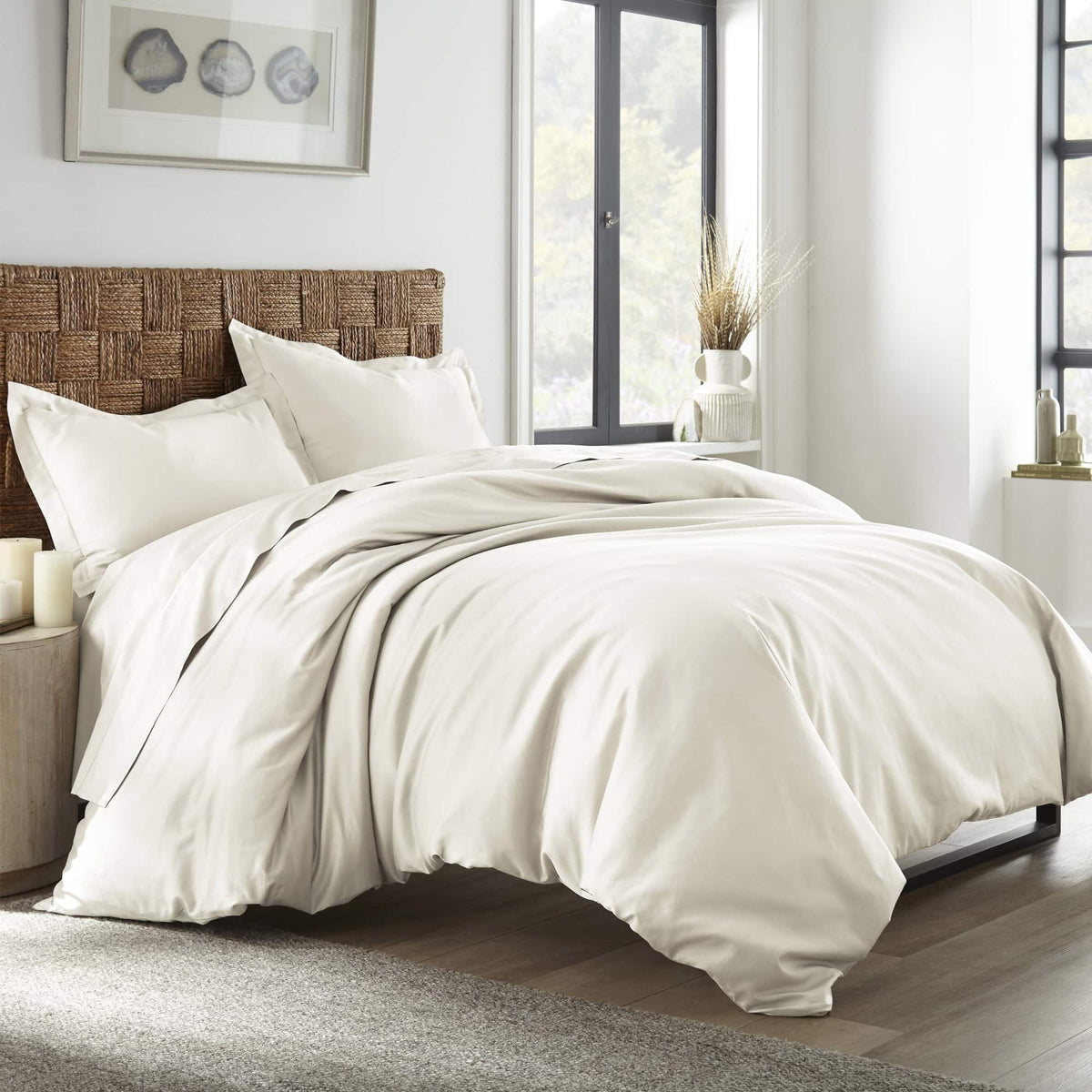 Cream oatmeal bedding arranged on bed near window showing soft folds and woven headboard
