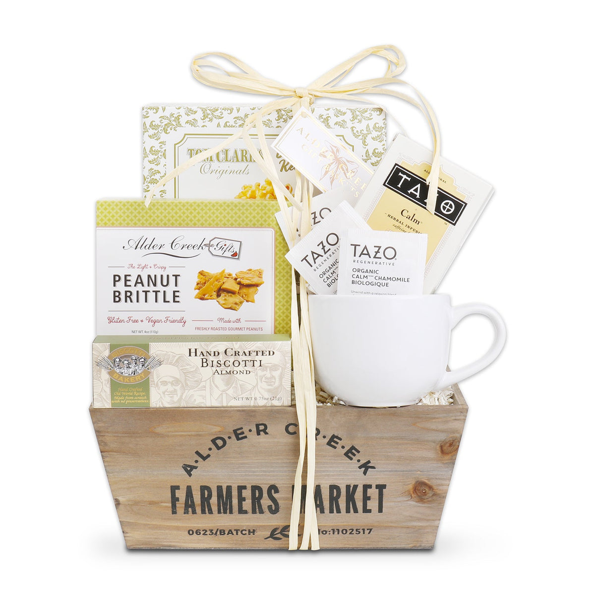 Wooden crate tied with cream ribbon containing snack boxes labeled gluten-free and vegan, plus Tazo tea packets in a white