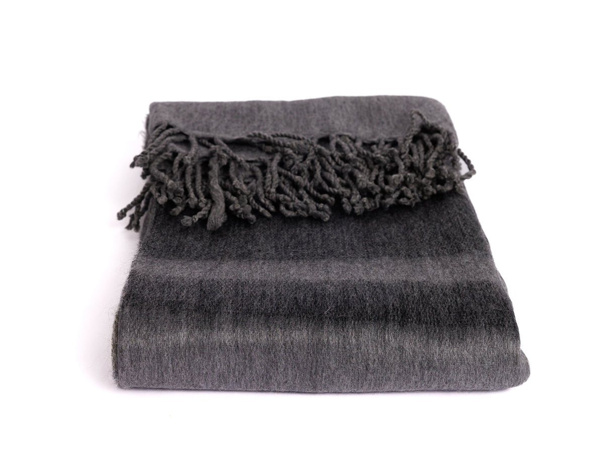 Folded luxury alpaca throw blanket emphasizing dense fuzzy surface and thick twisted corded fringe detail
