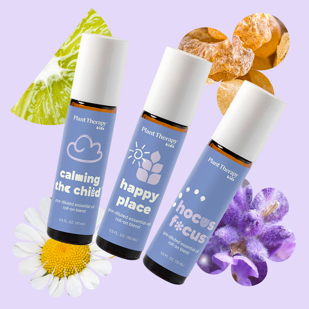 Three essential oil bottles floating diagonally on lavender surrounded by citrus peel, resin, daisy, and lavender blooms
