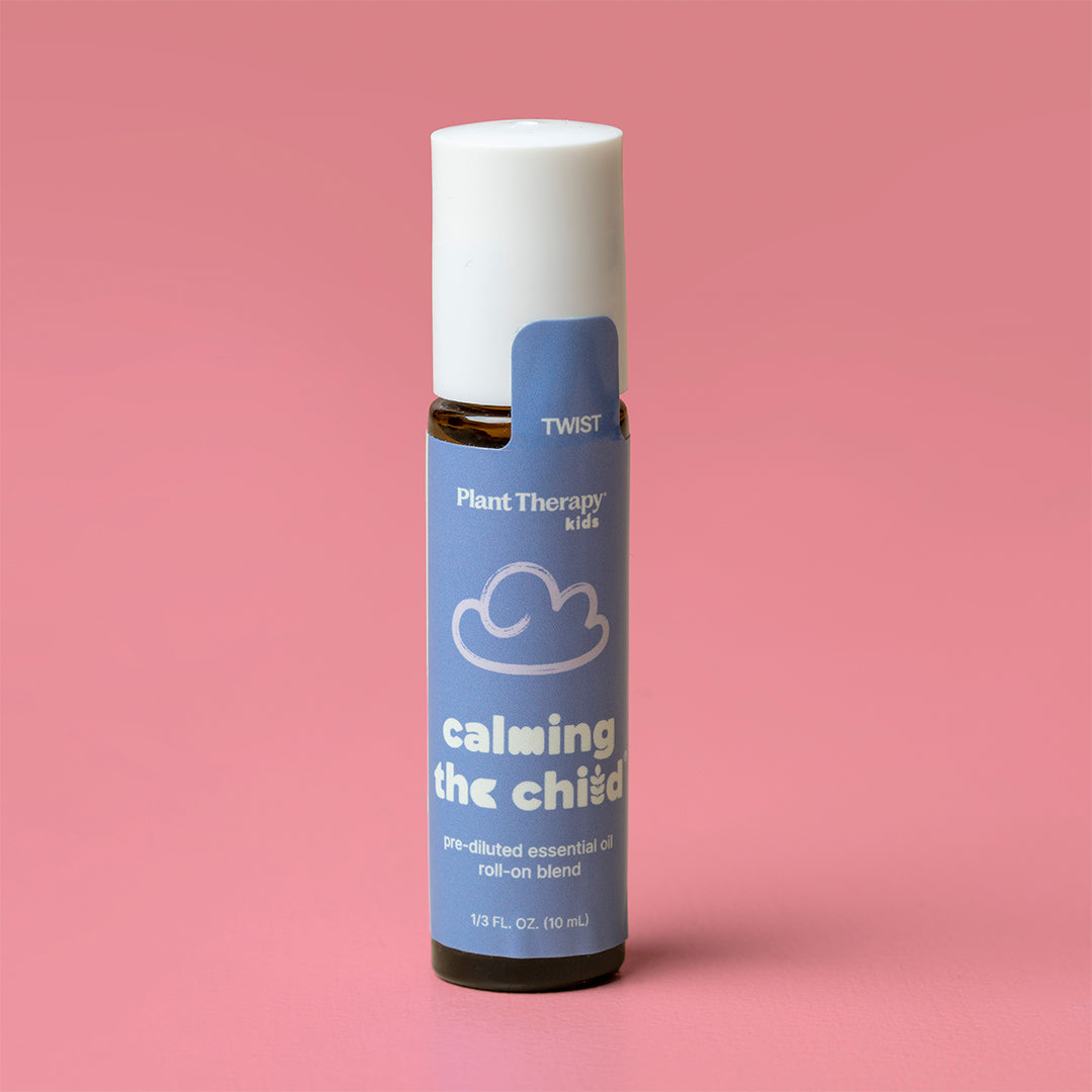 Single amber roll-on bottle with blue label and safety seal tab standing upright against a solid pink background