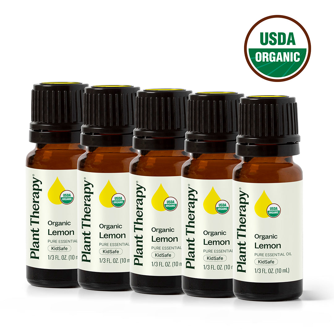 Five amber Plant Therapy organic lemon essential oil bottles in a row with USDA Organic seal and KidSafe label