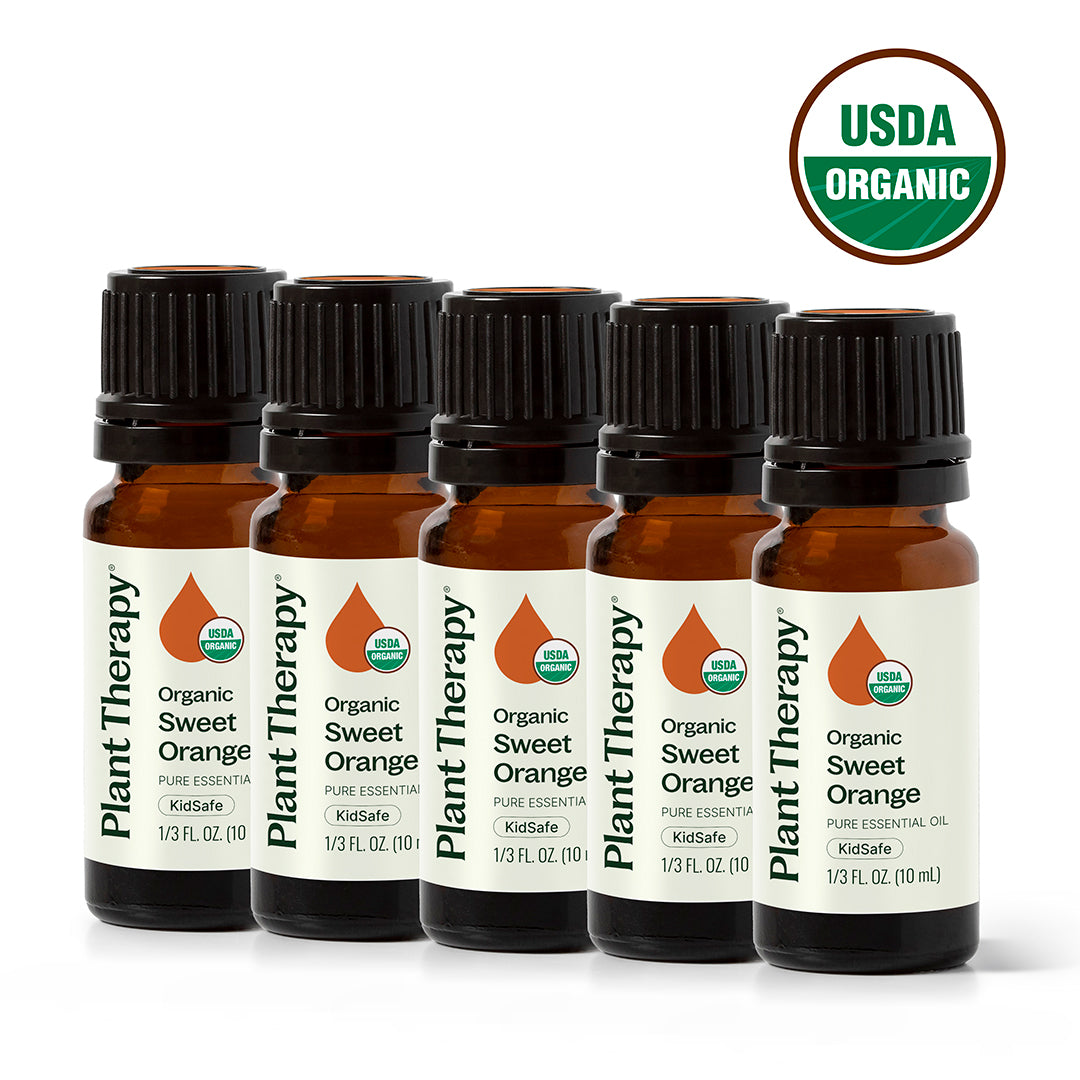 Five amber Plant Therapy essential oil bottles in a diagonal row with a USDA Organic seal on white