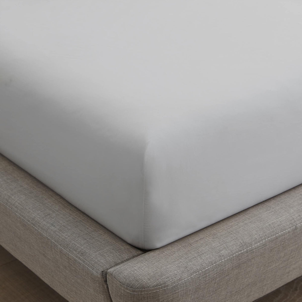 White fitted sheet corner stretched over mattress showing deep pocket elastic fit