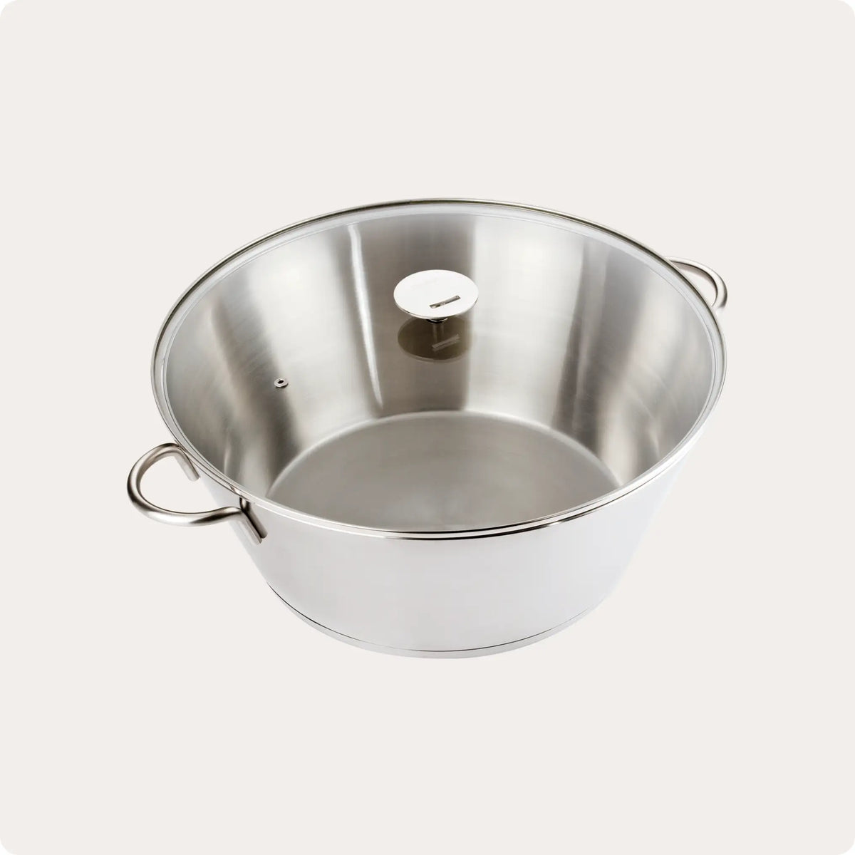 Stainless steel pot with loop handles and clear glass lid showing steam vent hole against white background