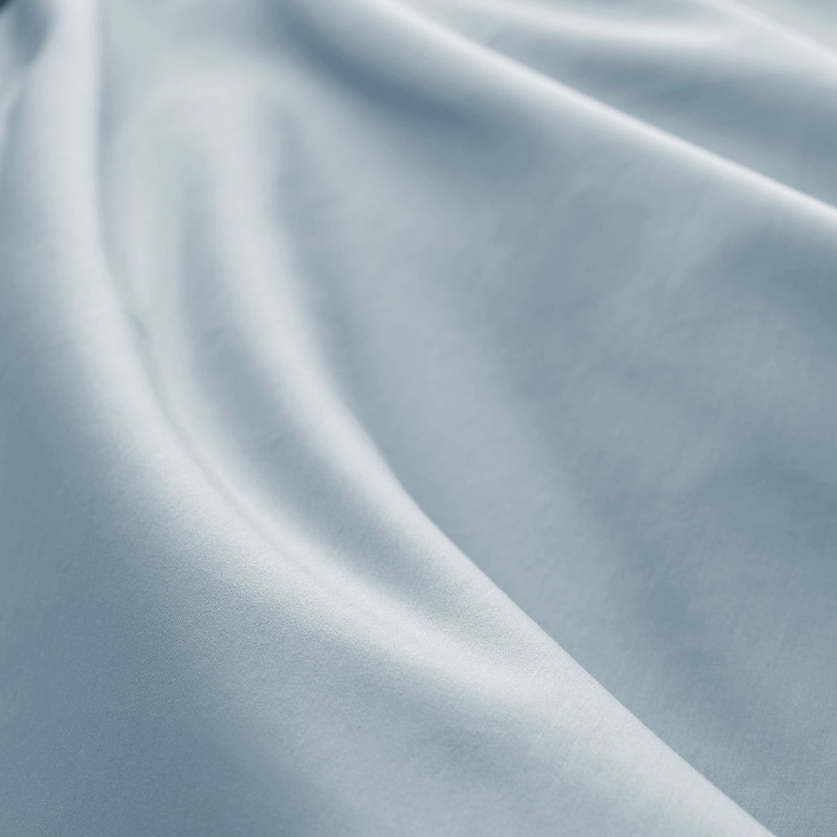 Macro close-up of light blue-grey 300 thread count sateen fabric showing fine weave, soft drape, and silky surface