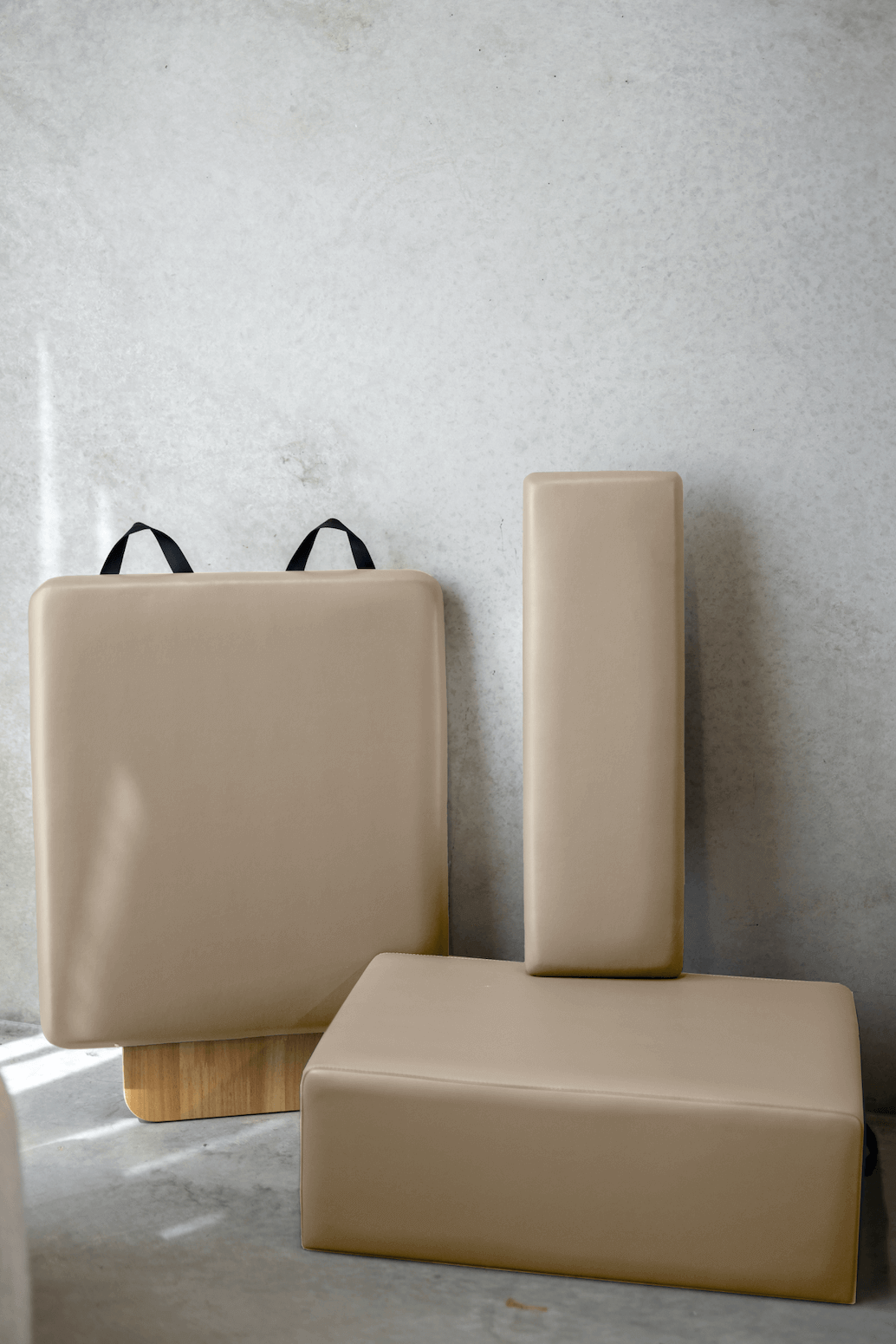 Tan Pilates square box and tall rectangular platform in minimalist soft natural lighting