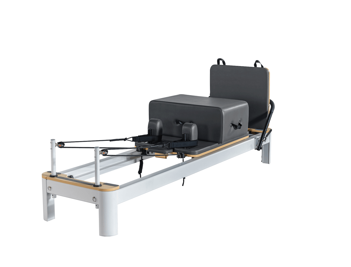 White frame Pilates reformer side profile featuring dark charcoal grey upholstery on carriage and box components