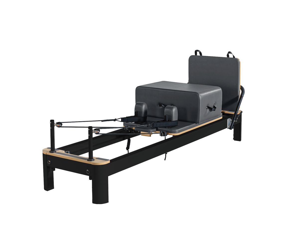Black framed reformer with dark charcoal grey padding on adjustable backrest and shoulder rests on white backdrop