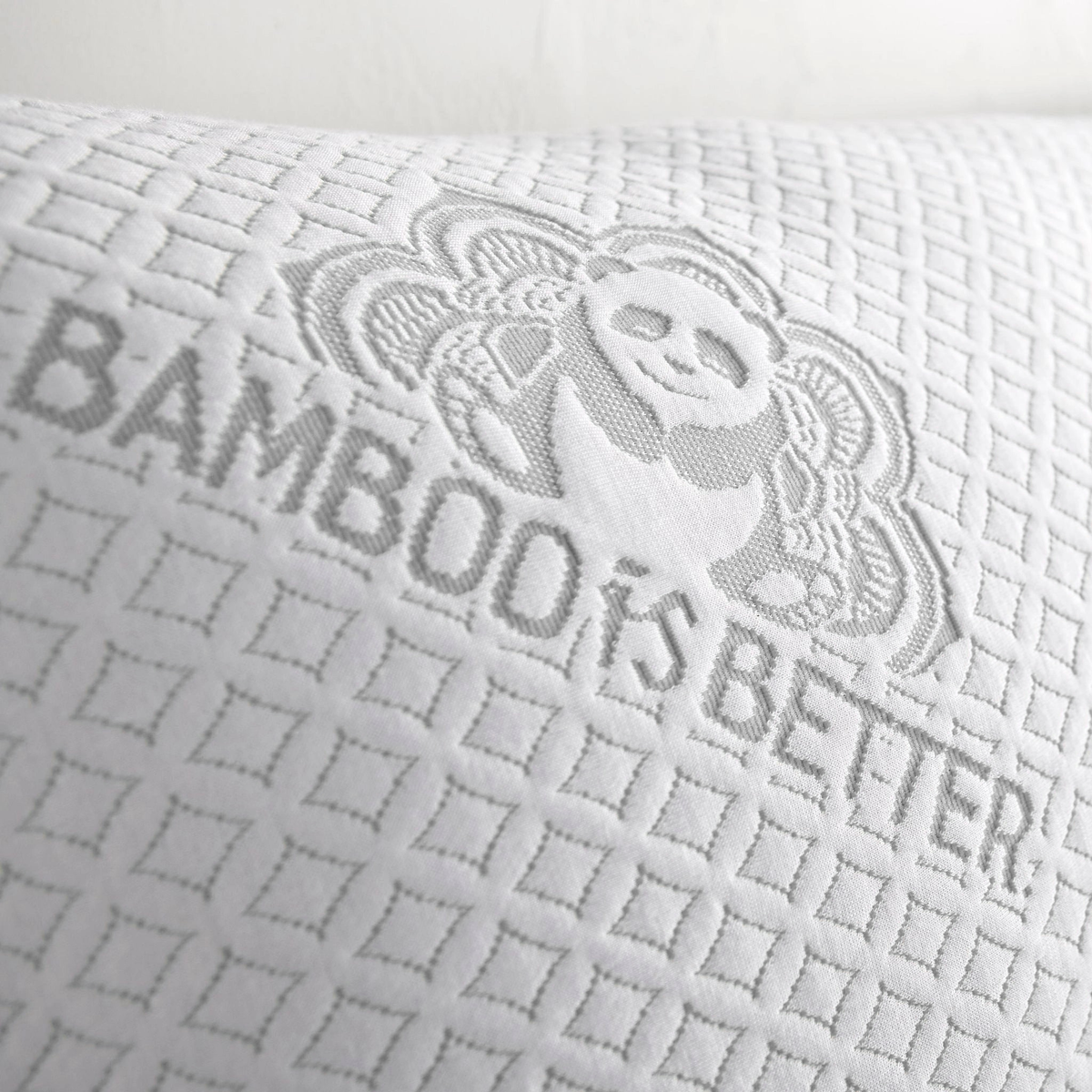 Macro shot of white fabric texture with grey embroidered bamboo brand text and panda logo
