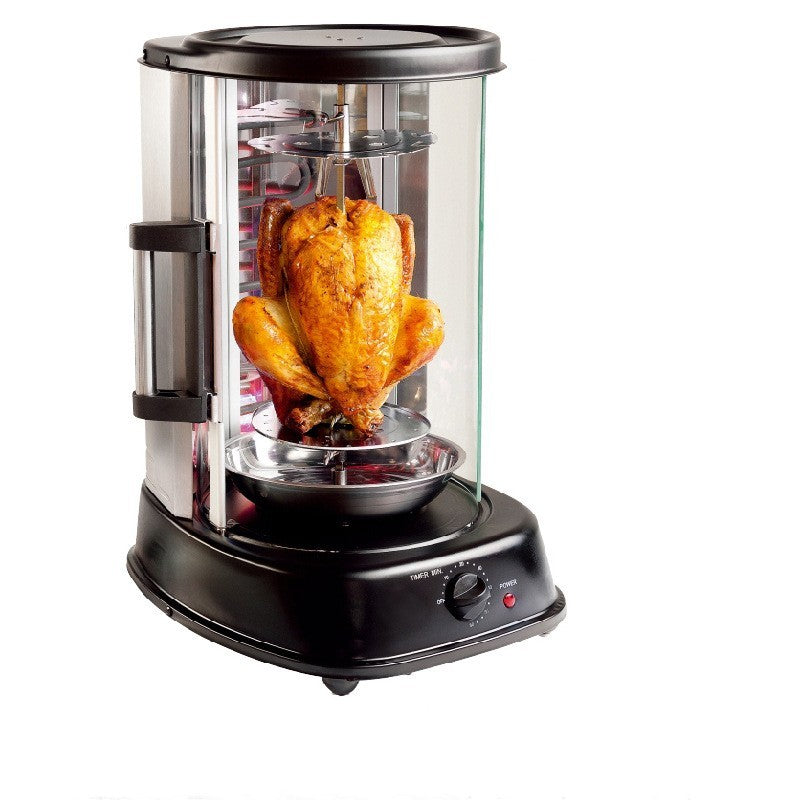 Whole roasted chicken secured on central spit inside transparent glass chamber of electric rotisserie, showing golden skin