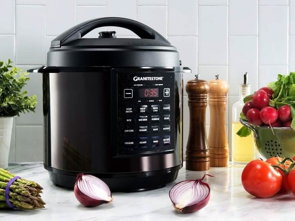 Black GraniteStone 6 quart multi cooker with digital control panel on marble counter surrounded by fresh vegetables