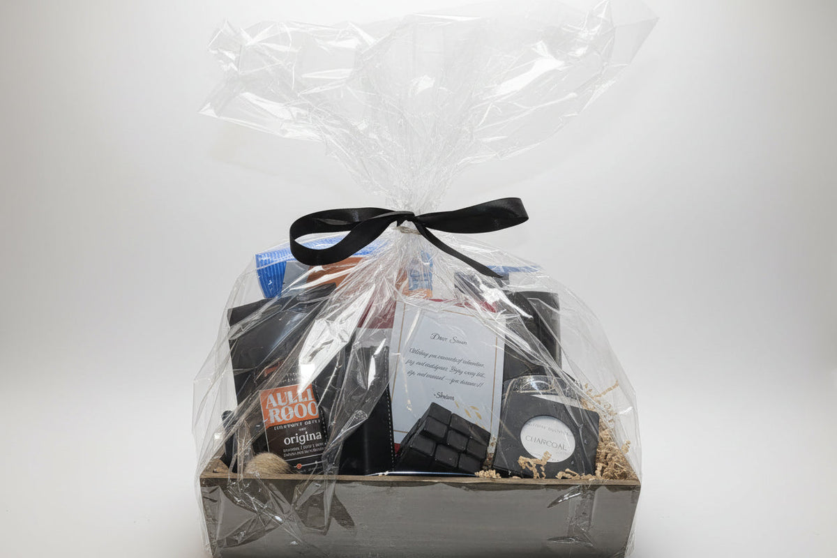 Rustic wooden crate gift basket for men wrapped in cellophane with black ribbon, containing chocolate and charcoal soap