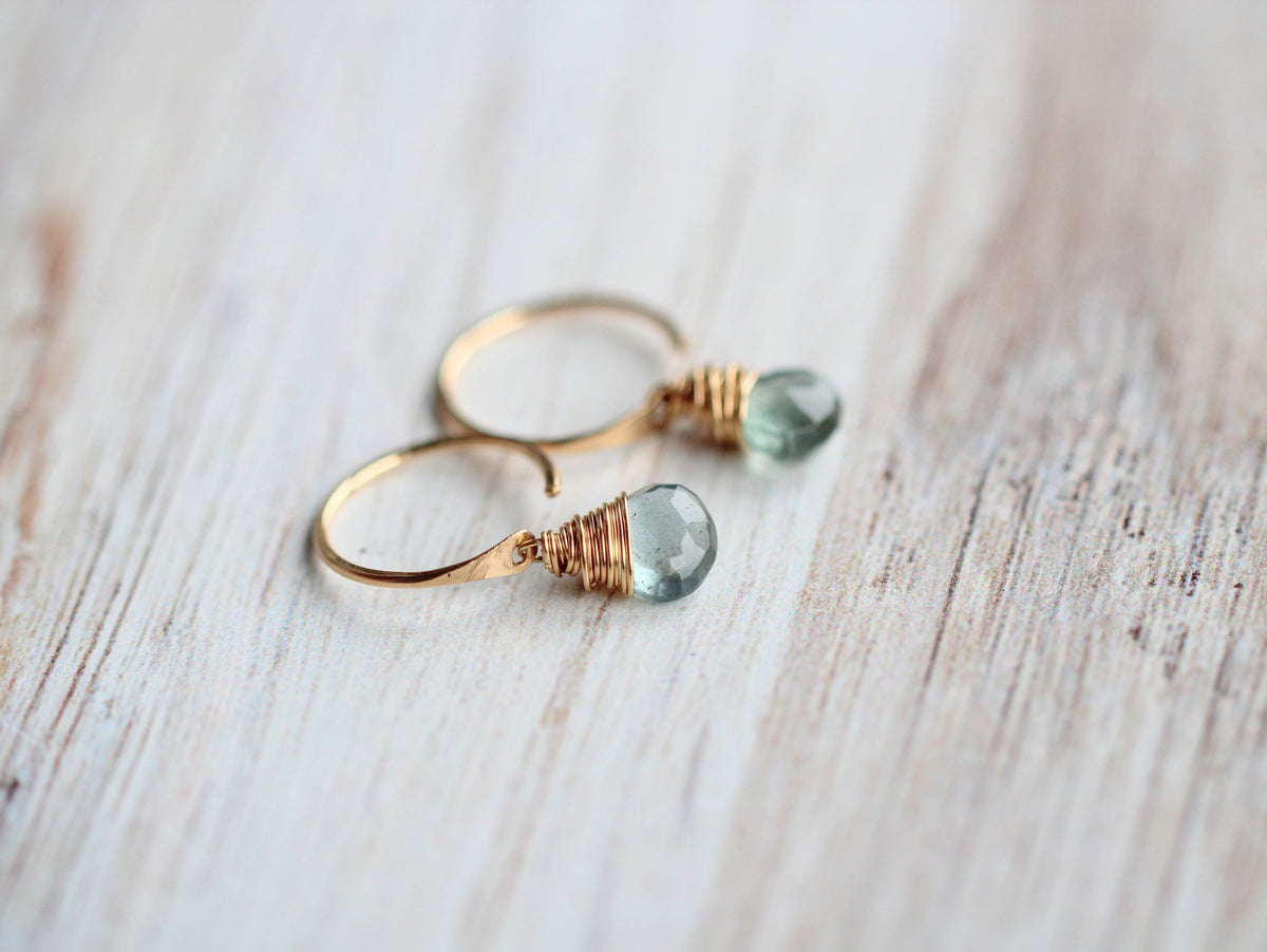 14k gold filled hoops with faceted light blue-green dangles on rustic wood