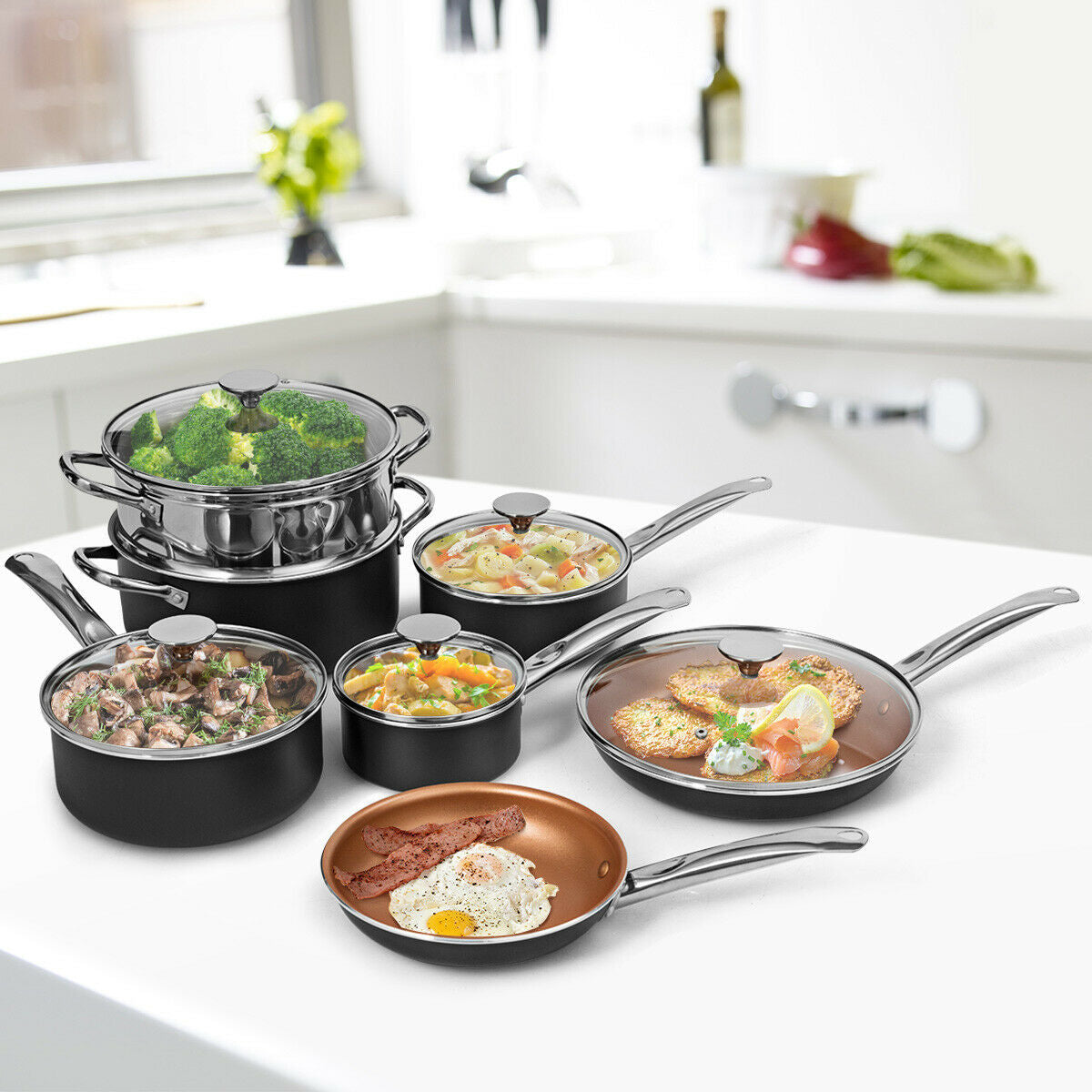 Black and copper cookware set on white counter with pots containing steamed broccoli, stew, soup, salmon cakes, and fried