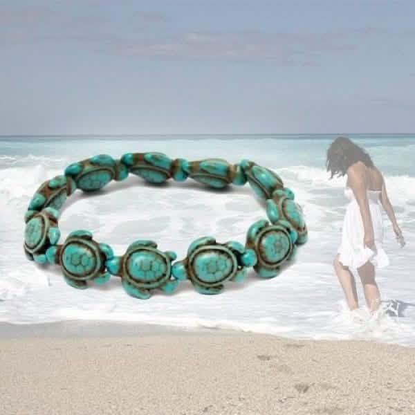 Turquoise sea turtle bracelet overlaid on beach scene with woman in white dress walking