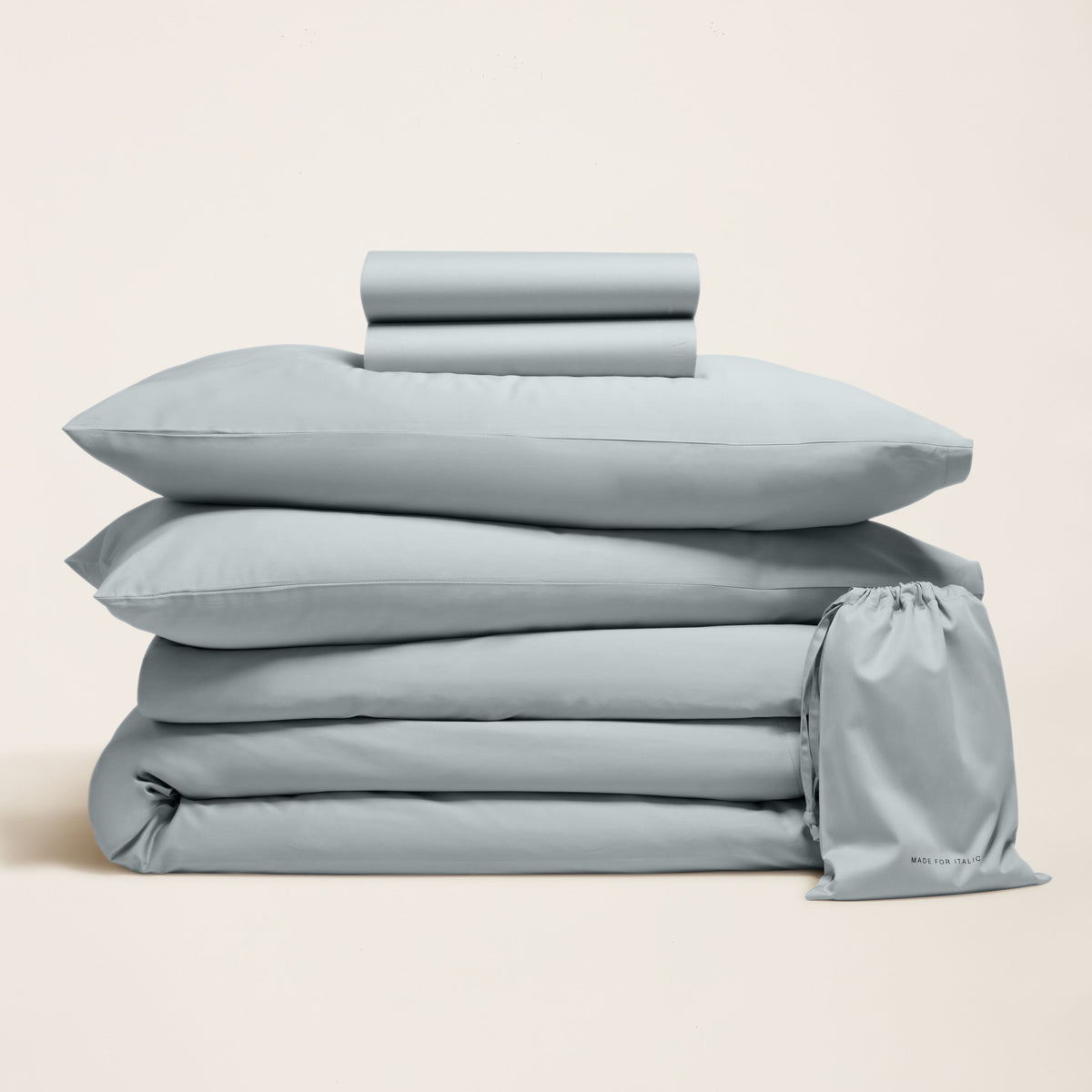 Muted grey-blue sateen cotton bedding bundle stacked to show components alongside a matching storage bag