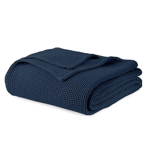 Navy blue waffle knit blanket folded on white background showing textured weave