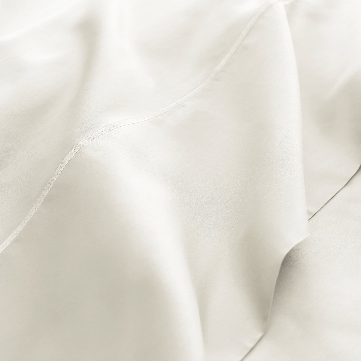 Macro shot of off-white sateen weave texture and fine stitching