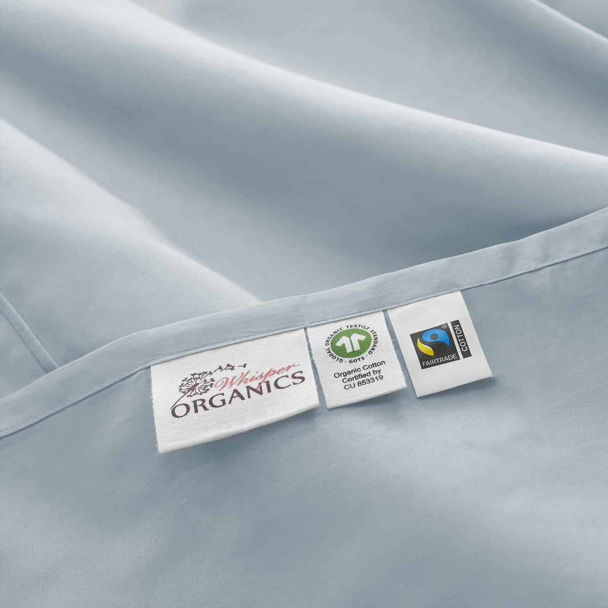 Product tags on light blue hem displaying GOTS Organic and Fairtrade certification marks