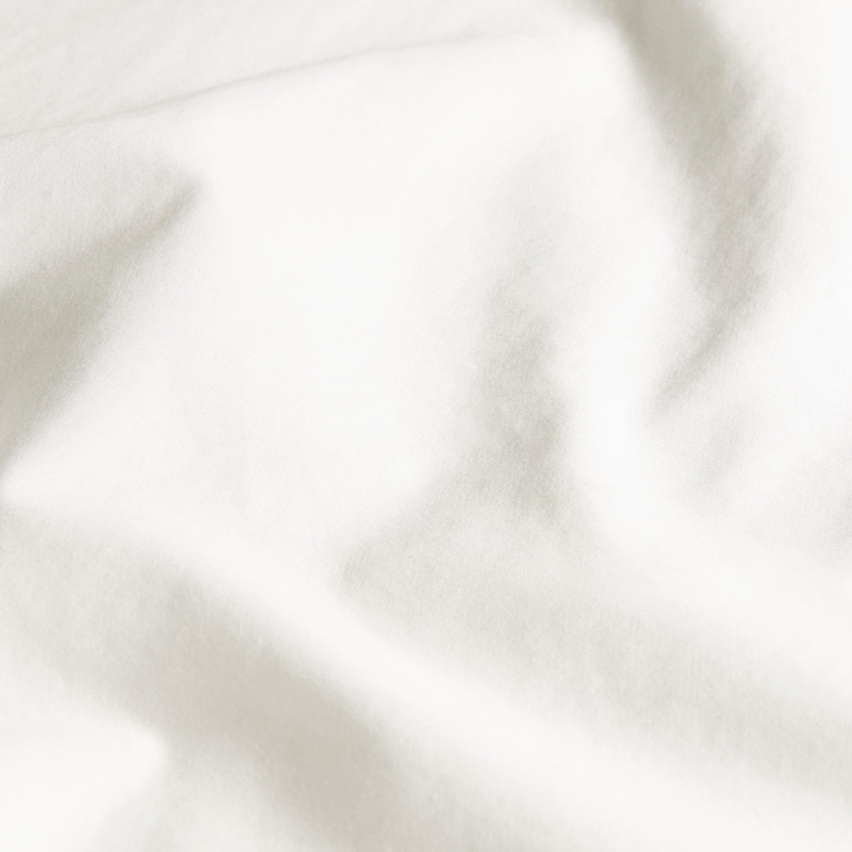 Macro close-up of white sateen fabric texture showing fine weave and sheen