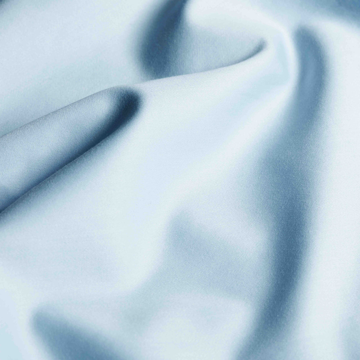 Macro close-up of light blue sateen fabric showing smooth weave and sheen
