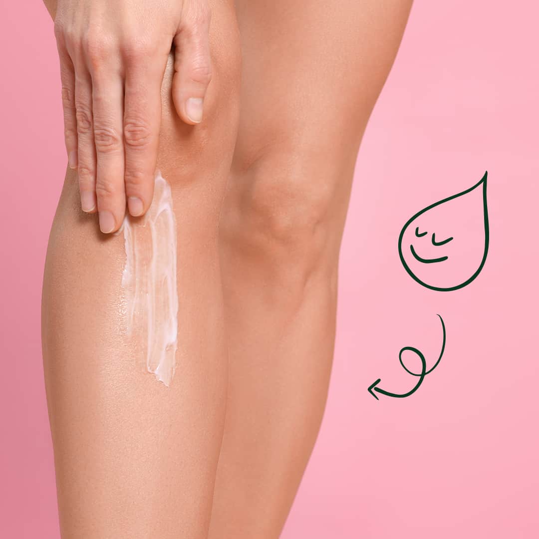 Person applying white lotion to leg against pink background with smiling droplet drawing