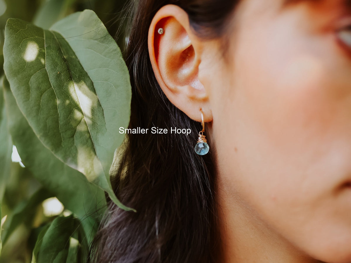 Close-up of model wearing smaller gold-filled hoop with moss aquamarine dangle