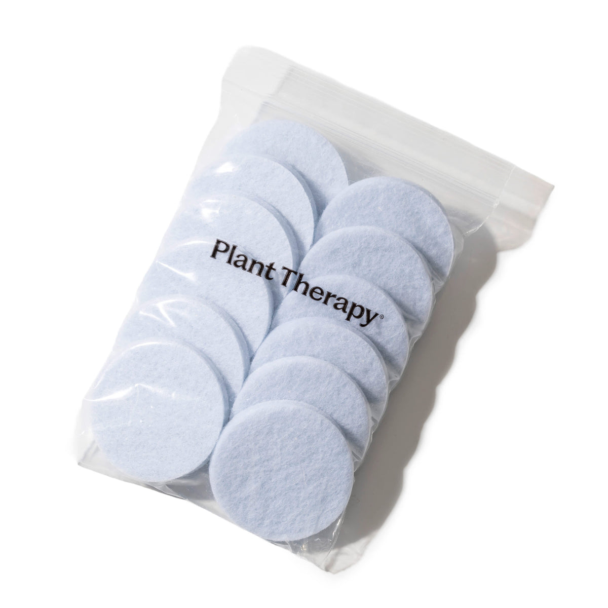 Clear plastic ziplock bag containing light blue circular reusable fiber pads with black Plant Therapy logo