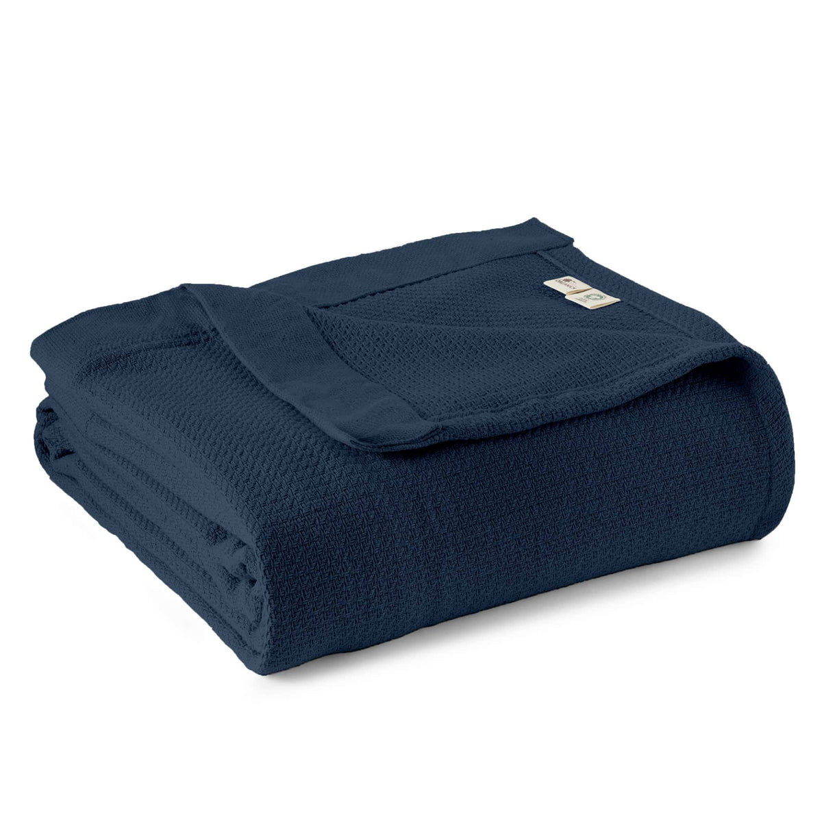 Stacked dark navy blue organic cotton blanket highlighting woven structure and certification tag