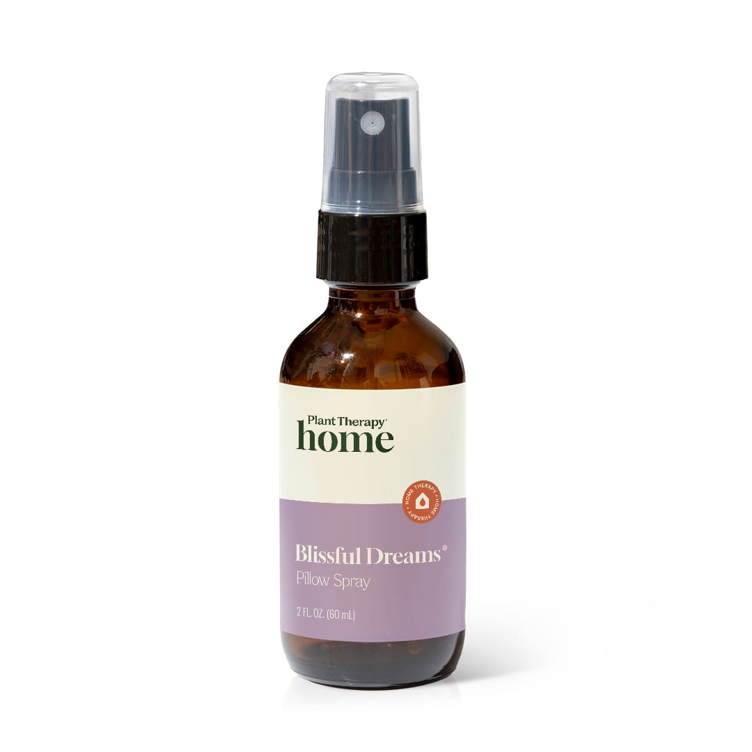 Amber glass spray bottle with black pump and lavender label on white background