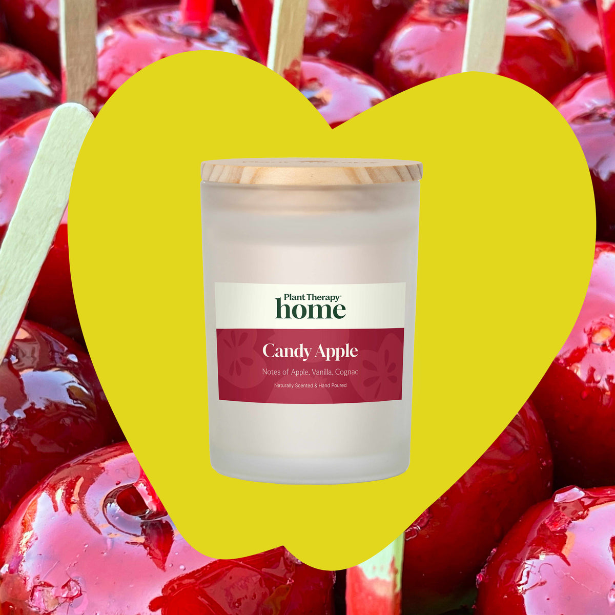 Candy apple candle inside yellow heart overlay on background of shiny red candy apples on sticks