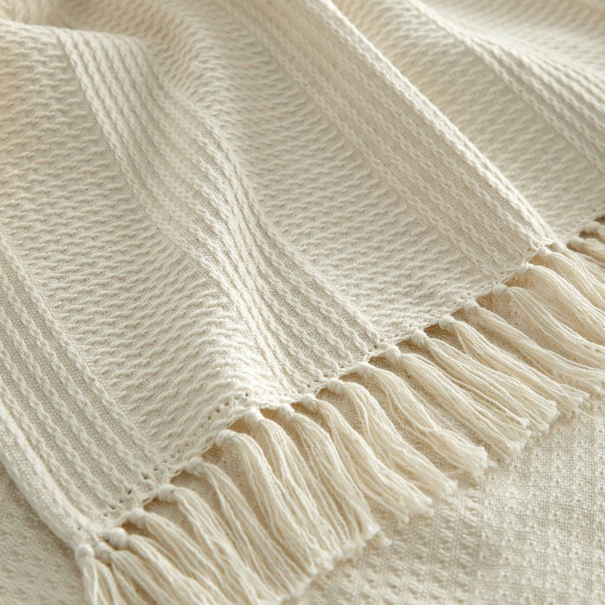 Close-up of ring-spun cotton waffle knit texture and hand-tied tassel details on border