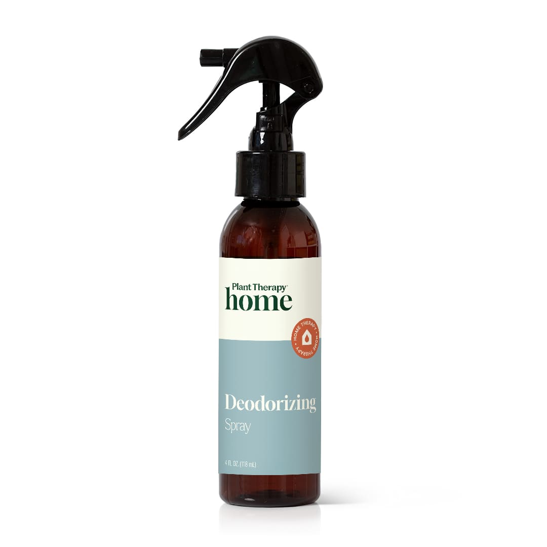 Amber glass spray bottle with black nozzle and cream blue label on white background