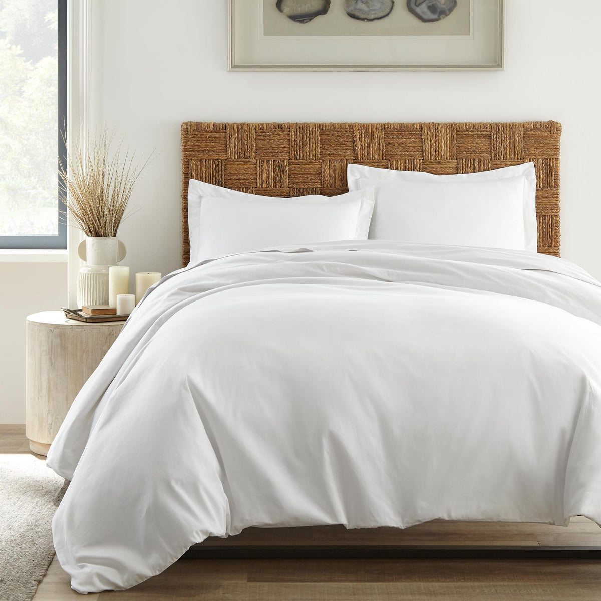 White duvet cover set on bed with brown headboard displaying decorative flange detailing on shams