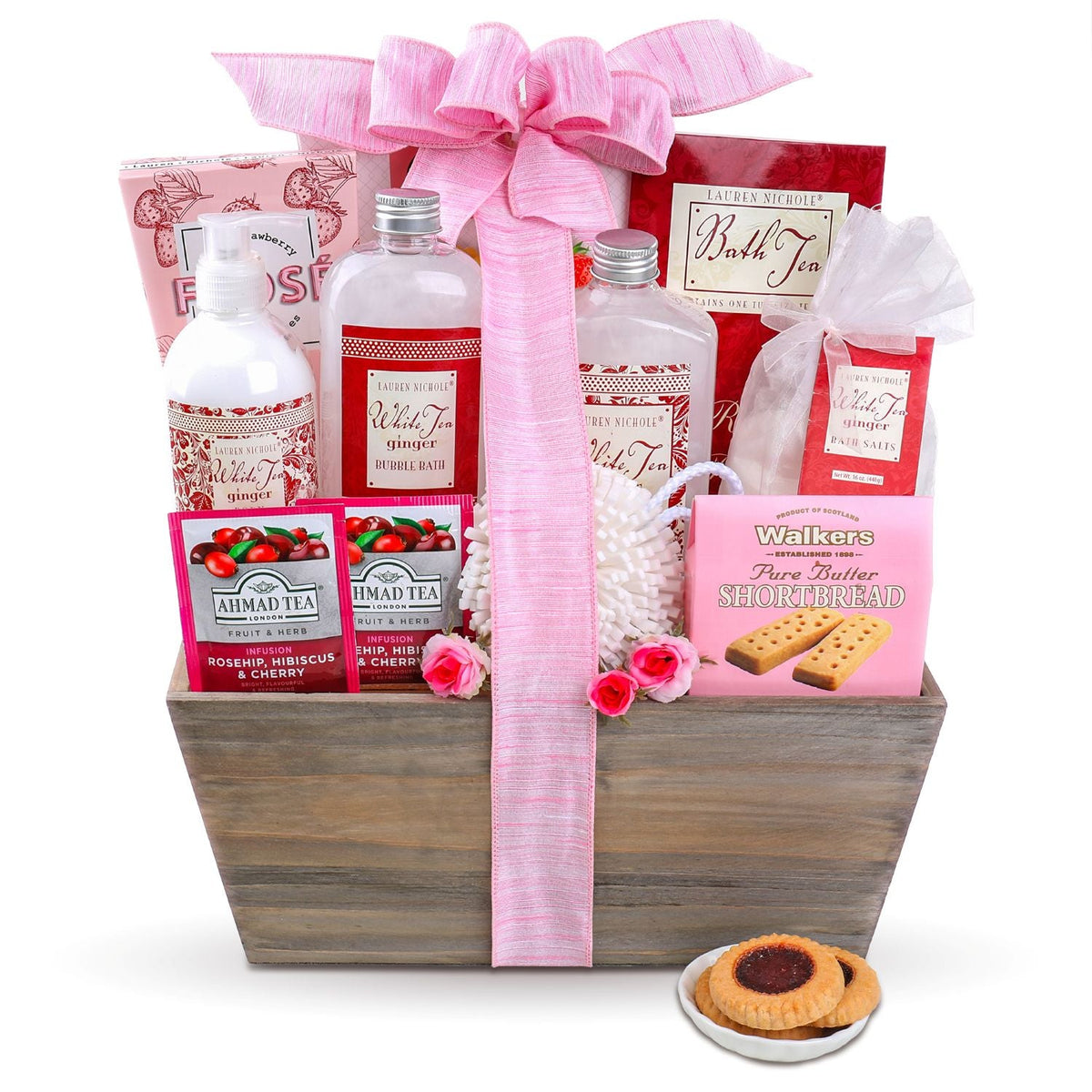 White background studio shot of the wooden gift basket showing bath salts, tea packets, and shortbread cookies inside