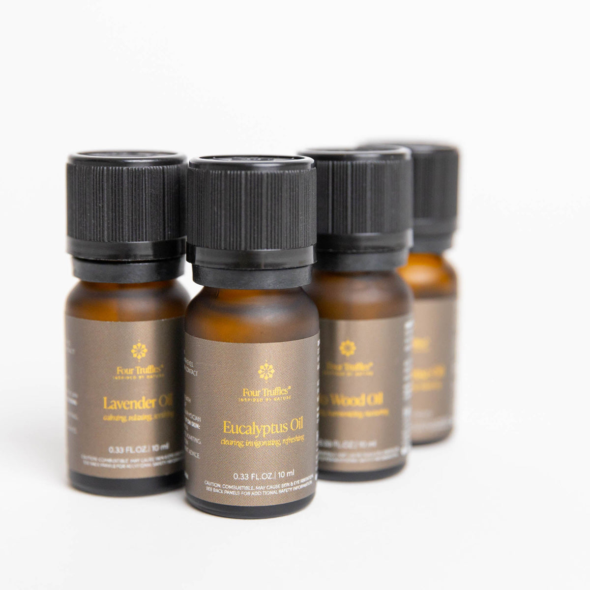 Angled close-up of grouped amber glass essential oil bottles highlighting texture and labels for Lavender and Eucalyptus oils