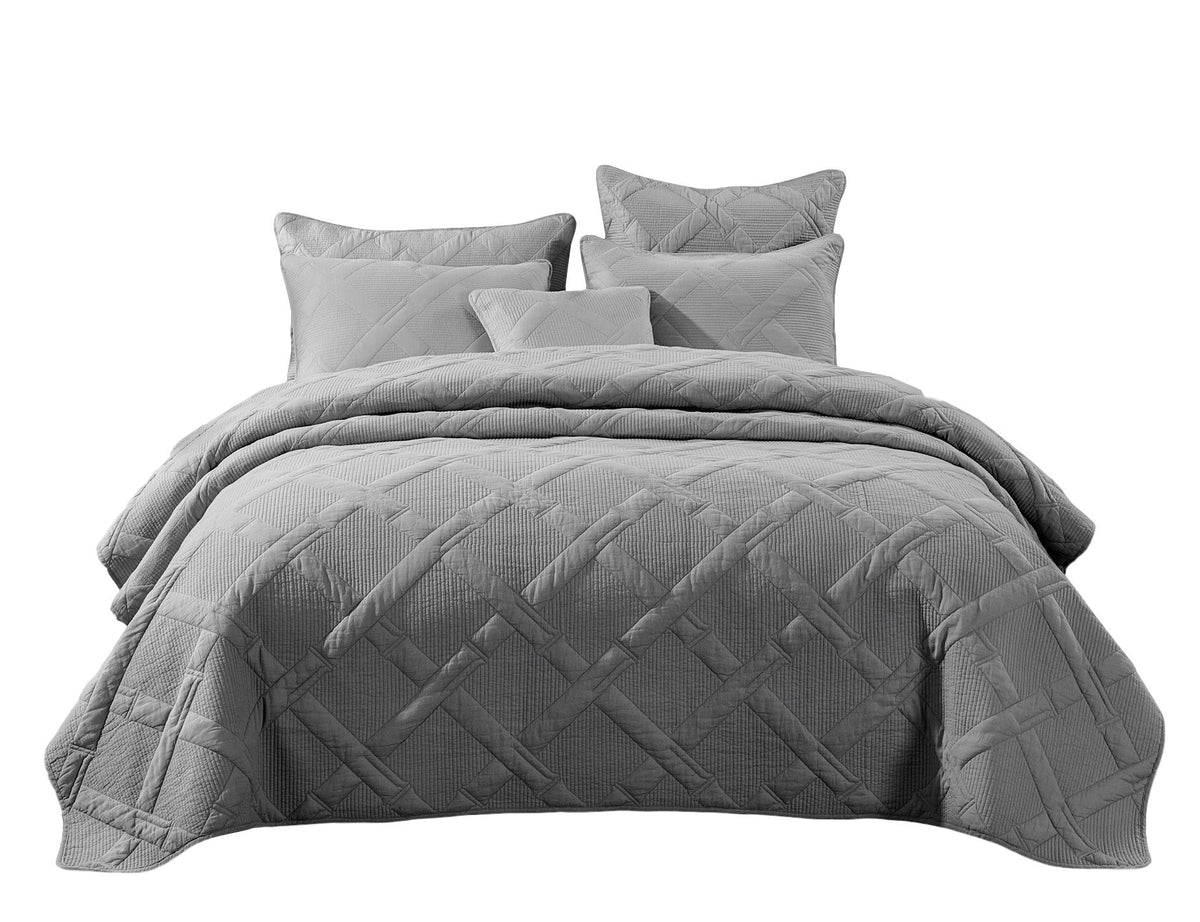Studio shot of complete light gray quilted bedding ensemble on a white background, including duvet cover with diamond design