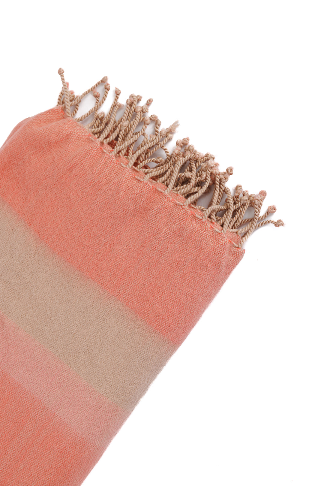 Macro close-up of alpaca throw corner revealing fine weave, smooth coral to beige stripe transition, and hand-tied fringe