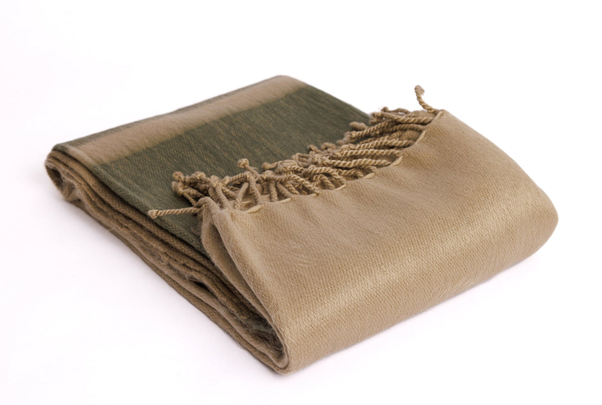 Folded luxury alpaca blanket displaying plush brushed surface texture and decorative edge tassels