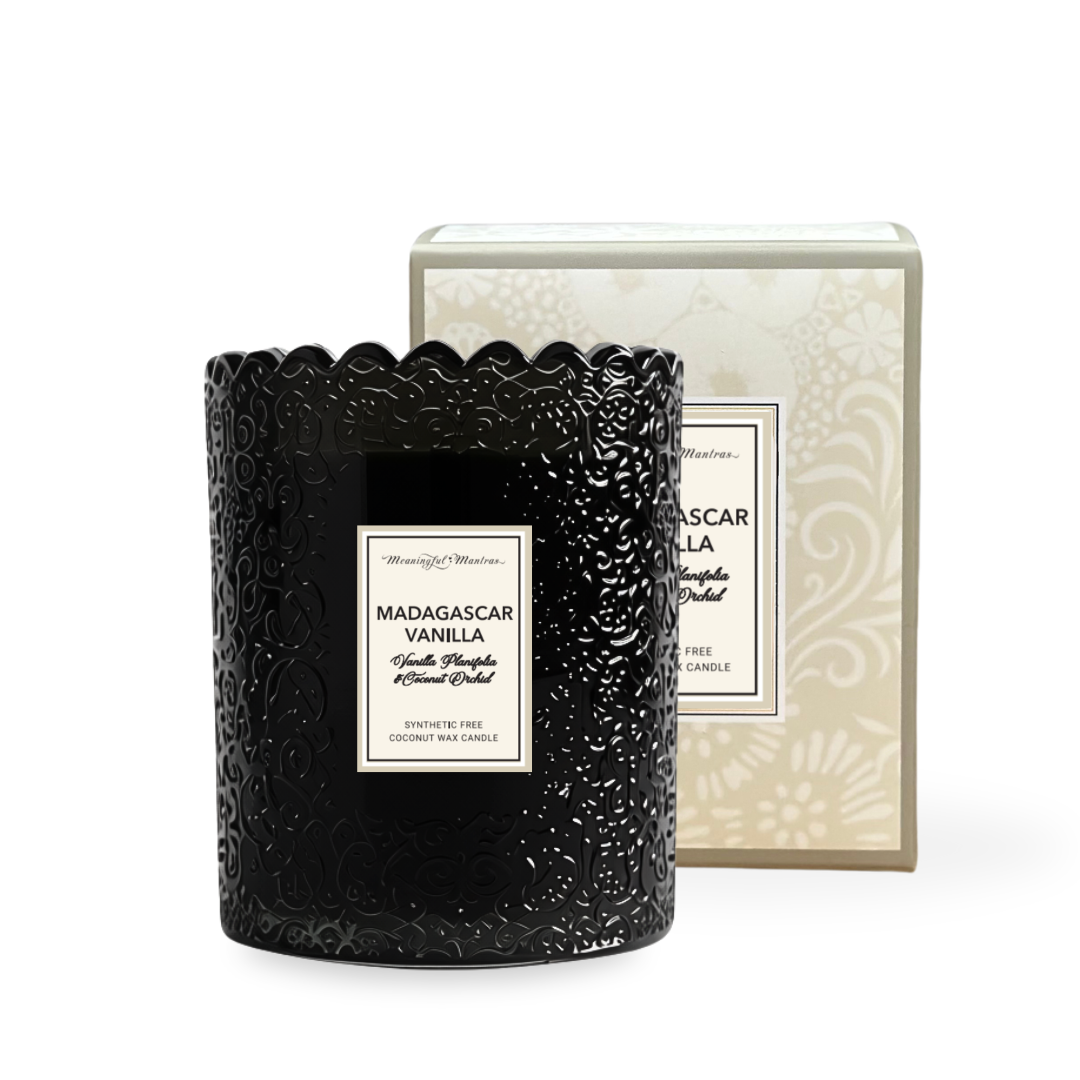 Glossy black 8oz candle with embossed floral pattern and scalloped rim, labeled Madagascar Vanilla on cream box