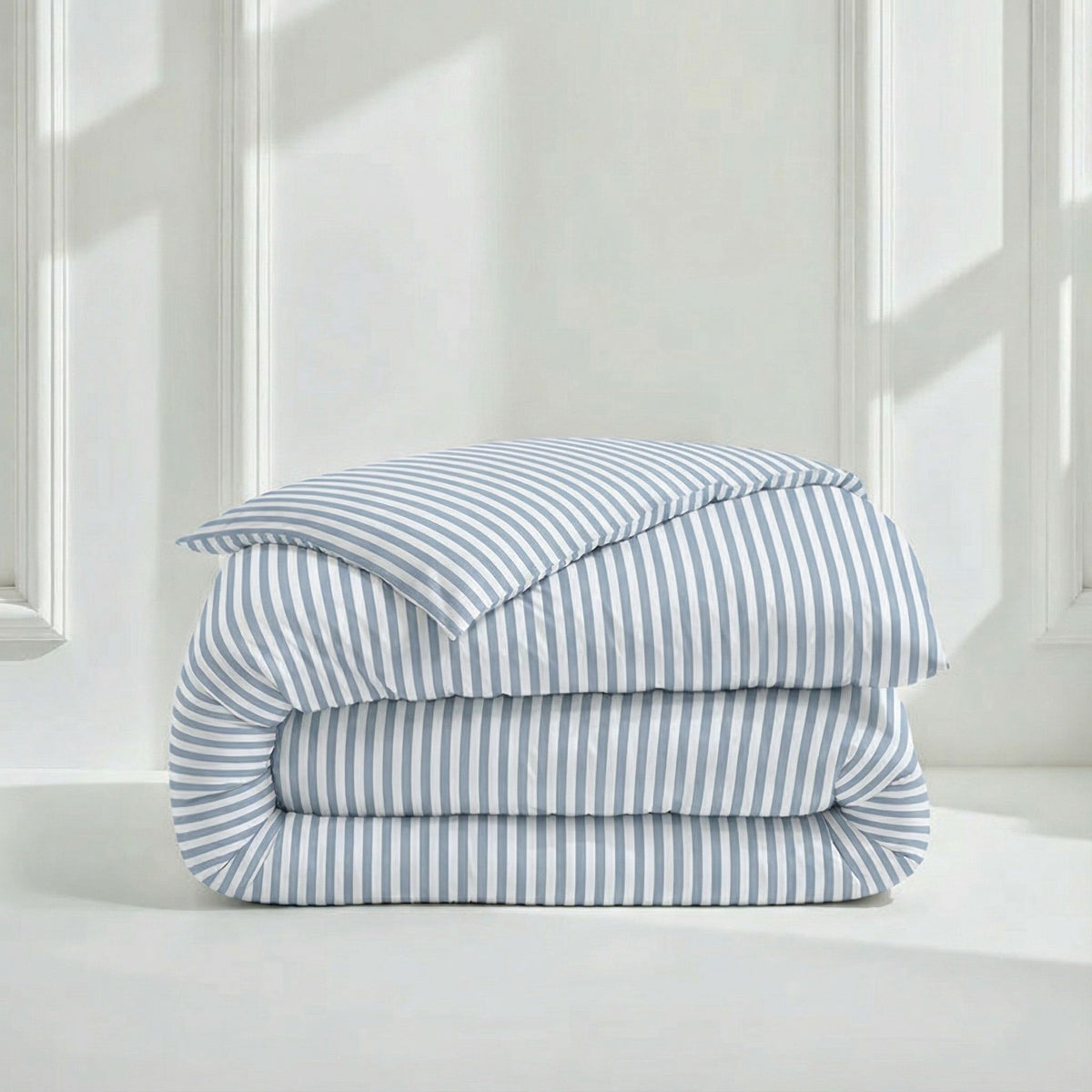 Blue and white vertical striped sateen duvet cover folded on white platform