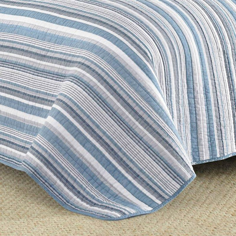 Close up of textured denim blue and white horizontal stripes on cotton quilt corner
