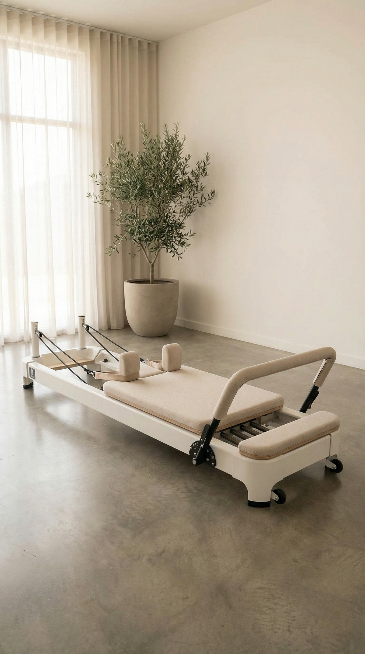 Beige upholstered Queen 2.0 Pilates Reformer with white frame in minimalist room