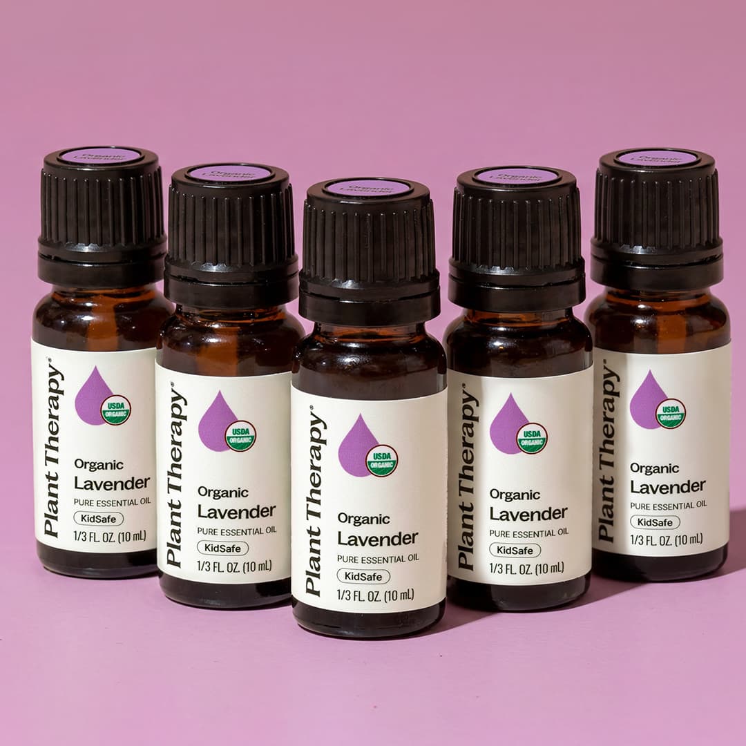 Staggered lineup of ten milliliter essential oil bottles on a pink background highlighting KidSafe certification